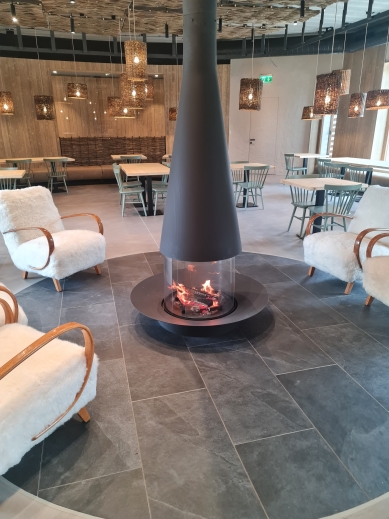 Fireplace with panoramic glass in the heart of a renovated farmhouse