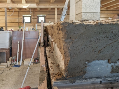 Heavy accumulation stoves with clay plaster as the dominant element of the log cabin - Construction of fireclay bricks. Traditional masonry material is used here as clay mortar as a binding agent for the fireclay shapes of the combustion chamber and for the placement of the absorber. - foto: Kamnářství Křivonožka